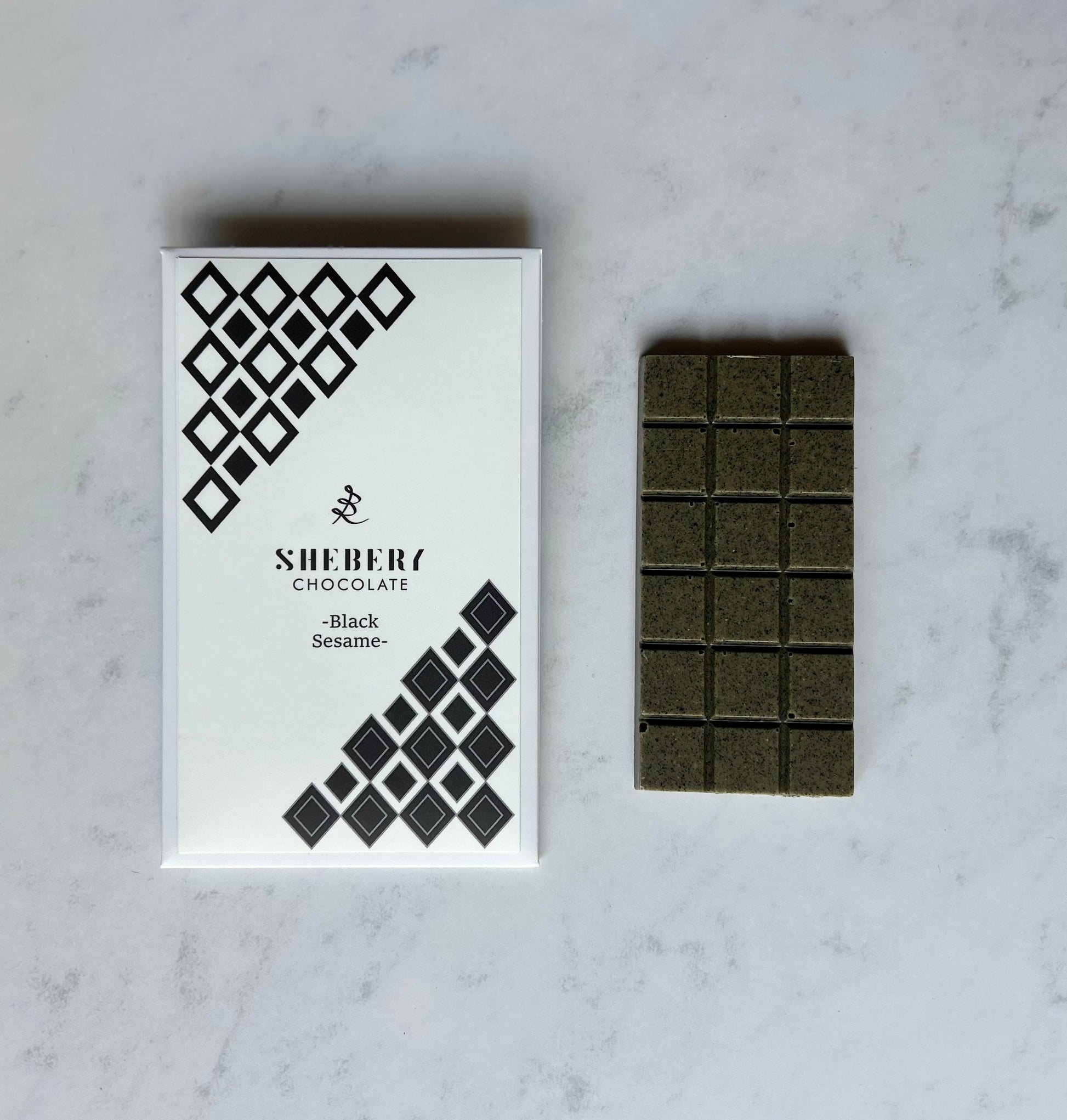 SHEBERYの黒ごまホワイトチョコレート“BLACK SESAME”。整う甘さをテーマにした、無添加・低GIのクラフトチョコレート。ギフトや毎日のおやつにもおすすめ。
