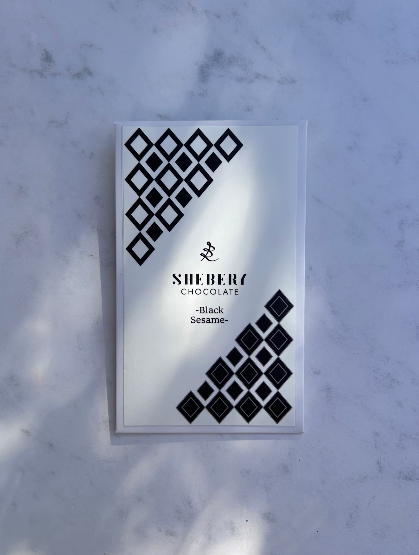 SHEBERYの黒ごまホワイトチョコレート“BLACK SESAME”。整う甘さをテーマにした、無添加・低GIのクラフトチョコレート。ギフトや毎日のおやつにもおすすめ。

